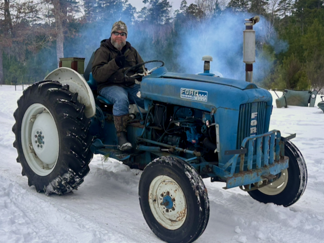 Joe on the blue Ford 2000 tractor in the snow